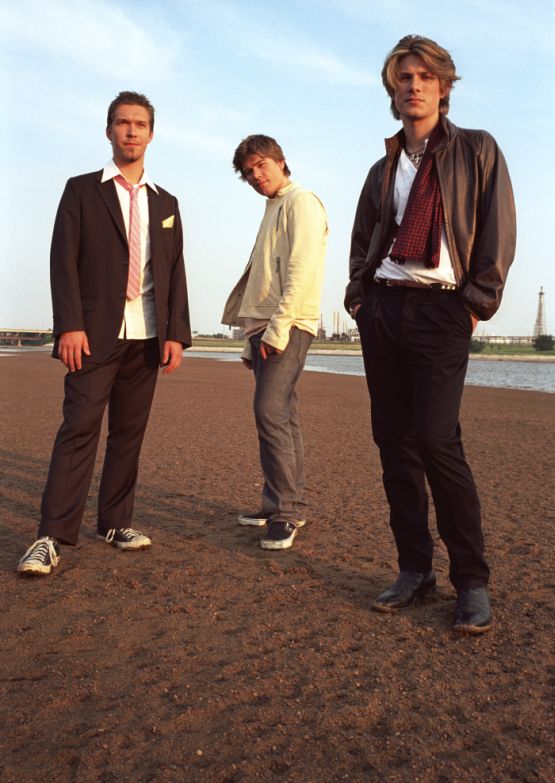 Taylor, Zac and Isaac Hanson standing in the sand